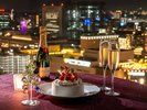 客室の窓越しに広がる横浜の夜景を眺めながら、ホテル特製のケーキとシャンパンで乾杯を。