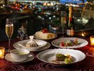 客室の窓いっぱいに広がるみなとみらいの夜景を眺めながら、シャンパンとともにコース料理を味わう一夜。