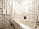【デラックスツイン】かわいらしい細工を施した白いタイル調のバスルーム
