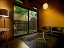 【新館・春花】春をイメージした洋室で、交差する梁は森のロッジのような趣。専用の坪庭とウッドデッキ付。