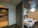 【客室】グランドツイン。アクセントの丸窓からやさしい光が降り注ぎます。