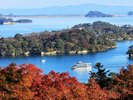 秋の松島。島々と海に浮かぶ遊覧船、紅葉が一緒に楽しめる。