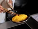 多くのゲストが立ち寄る LIVE COOK (実演コーナー)では、シェフがふわふわのオムレツを 作ります。