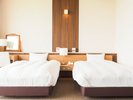 和洋室(8畳+ツインベッド):広々とした部屋で、ゆったりくつろげる和室にベッドをご用意しております。
