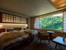 ツイン一例:山の緑を望めるコンパクトな洋室。