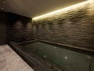 【The Spa ESPACIO MEIKAN】天然石で設えた大浴場とほの暗い照明で整えられたサウナ