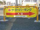 黄色の看板「サゴーパーキング」の入口が見えてきます。