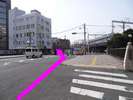 橋を渡ると前方に信号が・・その左斜め前に道が伸びています。