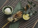 【お食事処/夕食一例】日本古来から伝わる原始焼きで虹鱒をご提供いたします。