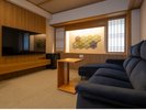 【本館 プレミアムツイン】49�uのゆとりの空間にローソファを配置した居間。