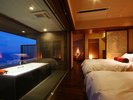 渚の館時じくスイートのベッドルーム。ビューバス越しに屋外を望む仕様です。