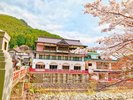 赤い橋のたもとにあるレトロなお屋敷旅館。春は桜、秋は紅葉が間近に。