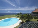 バルコニーからゴルフ場のグリーン、青い空、コバルトブルーの海と水平線を独り占めする眺望。