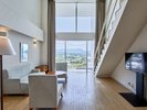 【メゾネット2ベッド】吹き抜けがもたらす圧倒的な開放感。窓一面に広がる沖縄の景色をリビングから堪能。
