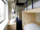 Bunk with Shared Bathroom�b2�i�x�b�h2��ƃe�[�u���Z�b�g������t�H�[�X�̂������ł��B