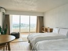 大きな窓から沖縄の景色を望む、自然光が心地よい開放的な客室
