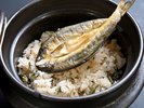 【夕食バイキング】香ばしい焼き魚をのせた、風味豊かな炊き込みご飯。