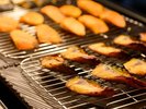 朝食バイキングでは、干物や数種類の焼き魚を炭火であぶって提供しています
