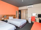 【ツインルームB】オレンジのソファーが印象的な温かみのあるお部屋でございます。