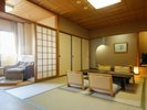 【露天風呂付き客室】低めのテーブルと座椅子が配置され、木のぬくもりが感じられる落ち着いた空間。