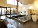 宿泊特典で無料!隣接する温浴施設「泉水」の内風呂。溶岩を使った浴槽で、体の芯からポカポカに。