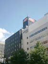 セブンイレブンの交差点にて、左手に見えるグレイ色のビルがアパホテル<TKP札幌駅前>でございます