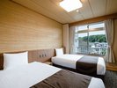 【スタンダードツイン/25平米】壁や天井を和風にしつらえたお部屋にベッドを2台備えたモダンな客室です。