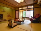 ゆとりある和室にマッサージチェアを備えた寛ぎの客室。畳の上で、心安らぐひとときをお過ごしください