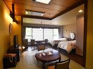 和室8畳とツインベッドを備えた、ゆとりある和洋室。畳の寛ぎとベッドの快適さを兼ね備えています