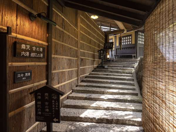 宿泊棟と湯小屋（里の湯）を繋ぐ竹灯篭と石畳のアプローチ