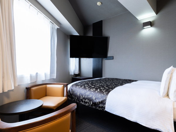 ダブルルームの客室です。テレビが壁掛けのお部屋となります。
