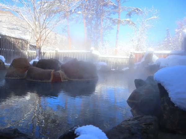 【大浴場露天風呂：冬】白い湯気が立ち込む露天風呂からは、幻想的な風景をご覧いただけます。