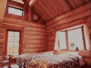 吹き抜けの天井・出窓付のお部屋。客室もログのつくりで、木のぬくもりが疲れを癒す