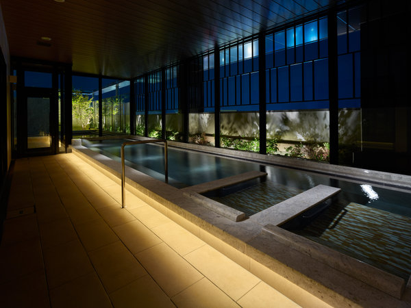 男性大浴場内湯【夜】ライトアップされた幻想的な水景を眺めながらお過ごしください。