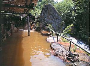 黄金の露天風呂はかけ流しで大きな岩が印象的