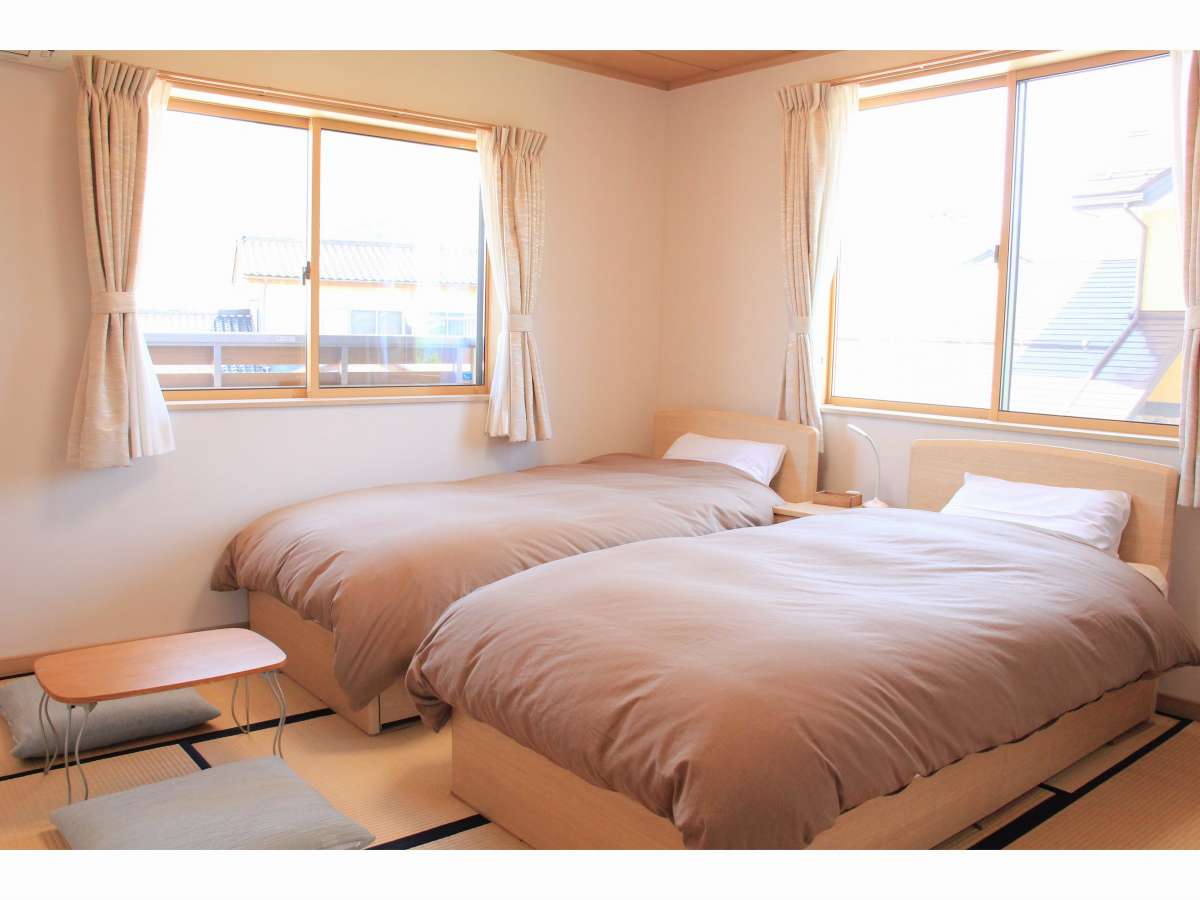 ８畳のお部屋にベッド２台を設置した和洋室です。畳スペースに布団を追加で敷いて３名様利用もできます。
