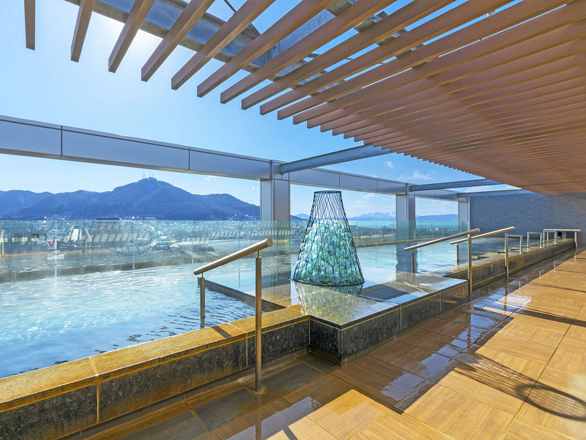 【大浴場】天空露天風呂からは函館山を一望。昼は明るい日差しが差し、夜は幻想的な雰囲気に…。