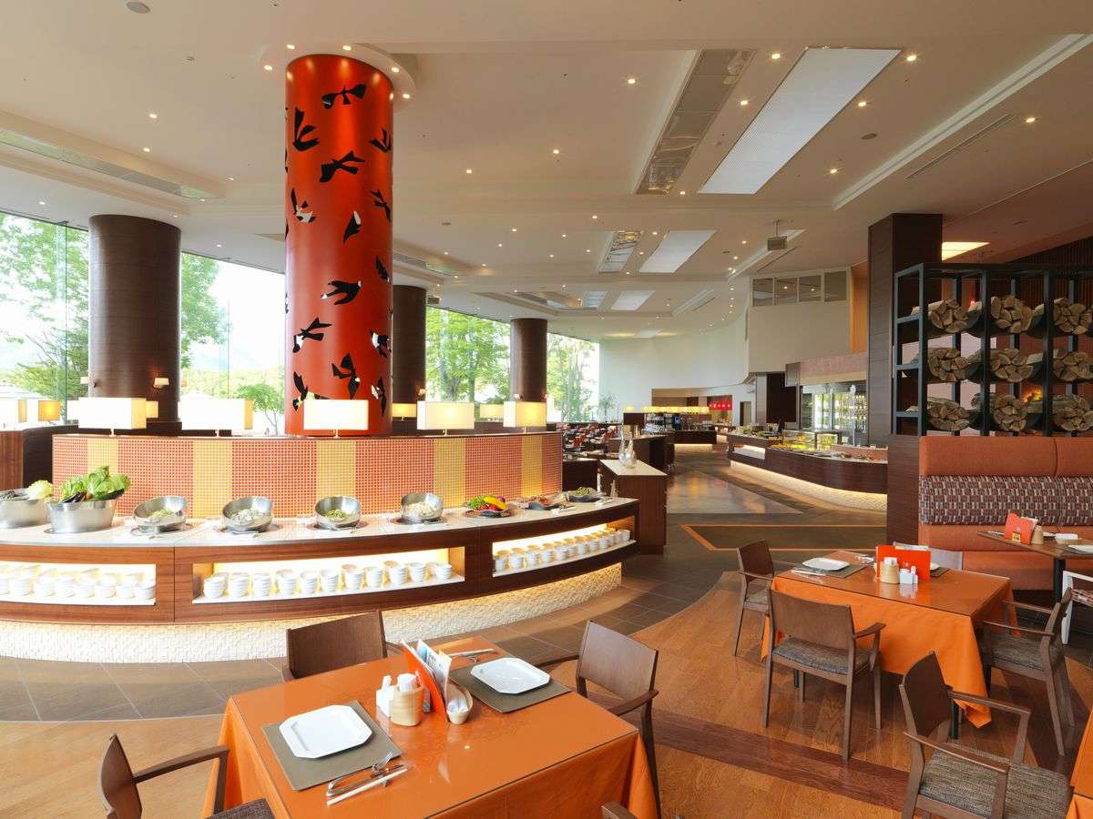 【ビュッフェレストラン「HAPO」】天井高6.5メートルの大空間にそびえるオレンジ色の暖炉が印象的