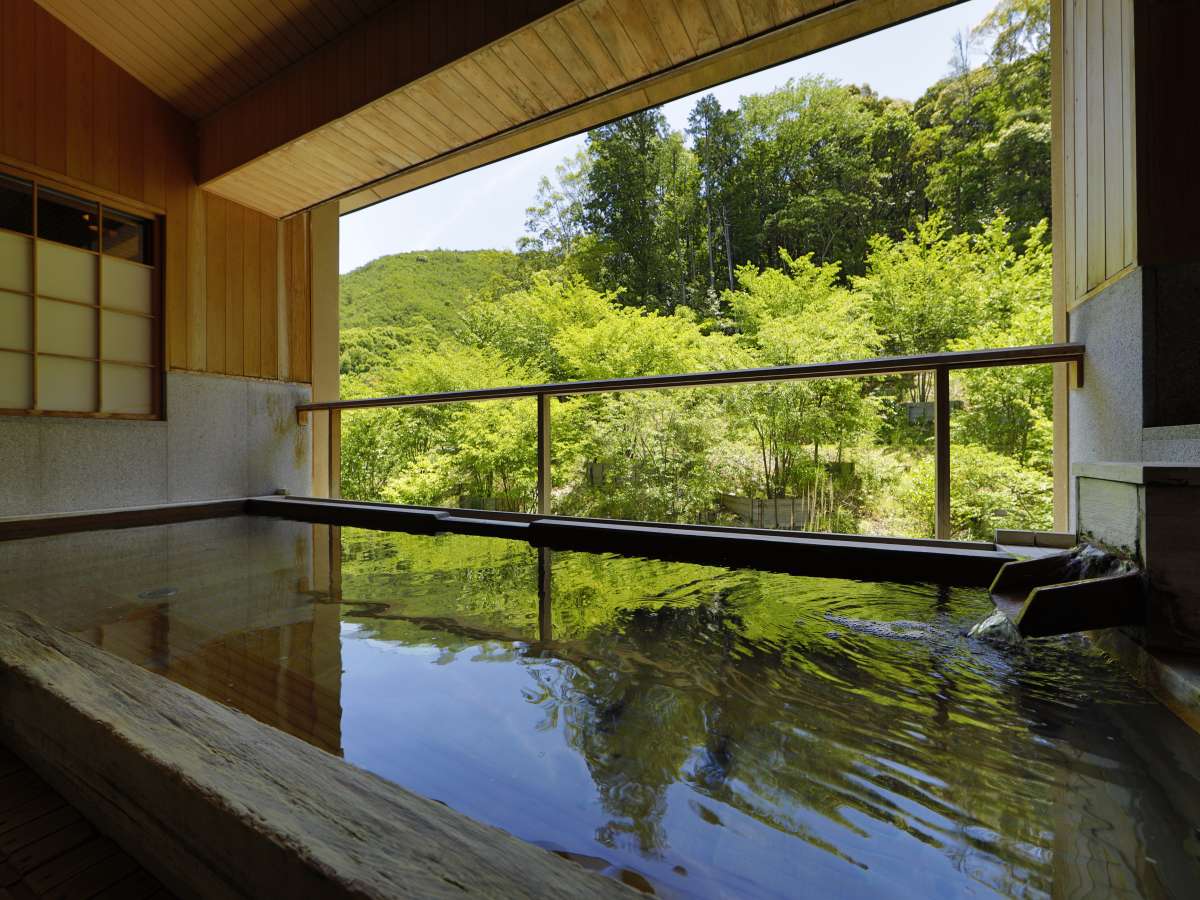 【大浴場/社の湯】檜の香りが漂う大浴場は、森の緑とは対照的な温かみのあるつくりとなっています。