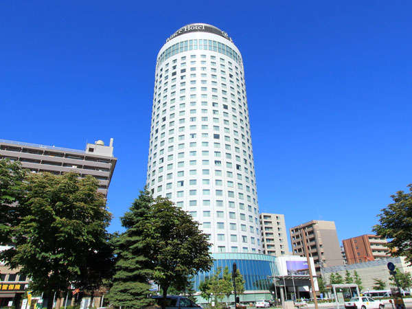 青く鮮やかな夏空の中、白い円柱形が映える札幌プリンスホテル