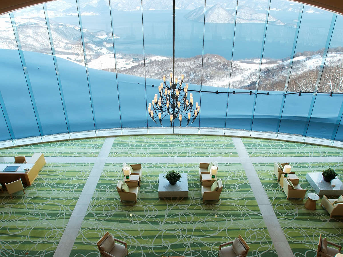 【ロビー】 ホテルを象徴する大きなガラス窓から見えるは、洞爺湖と大自然が織りなす壮大なパノラマ。