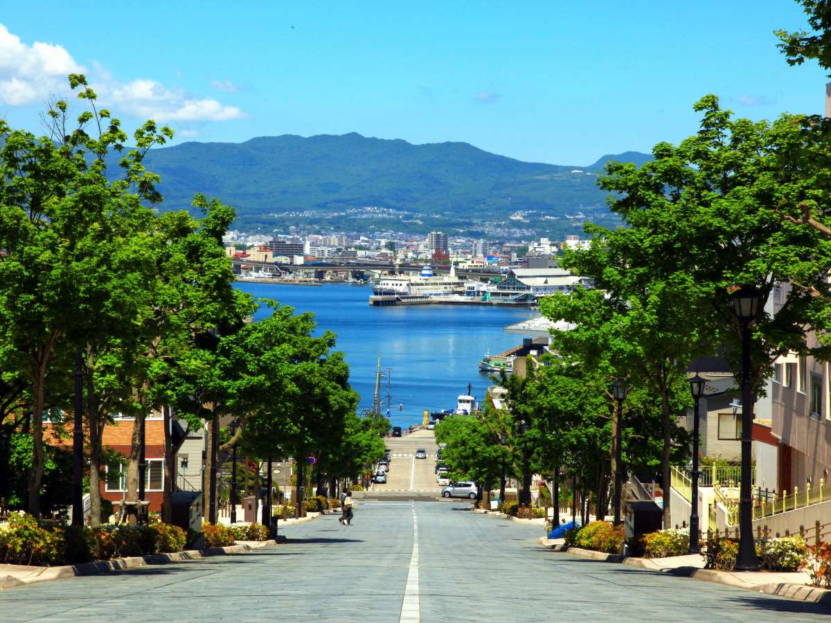 八幡坂は人気のある記念写真スポットで映画やCMのロケ地としても有名。石畳の坂の向こうに、海が見渡せる。