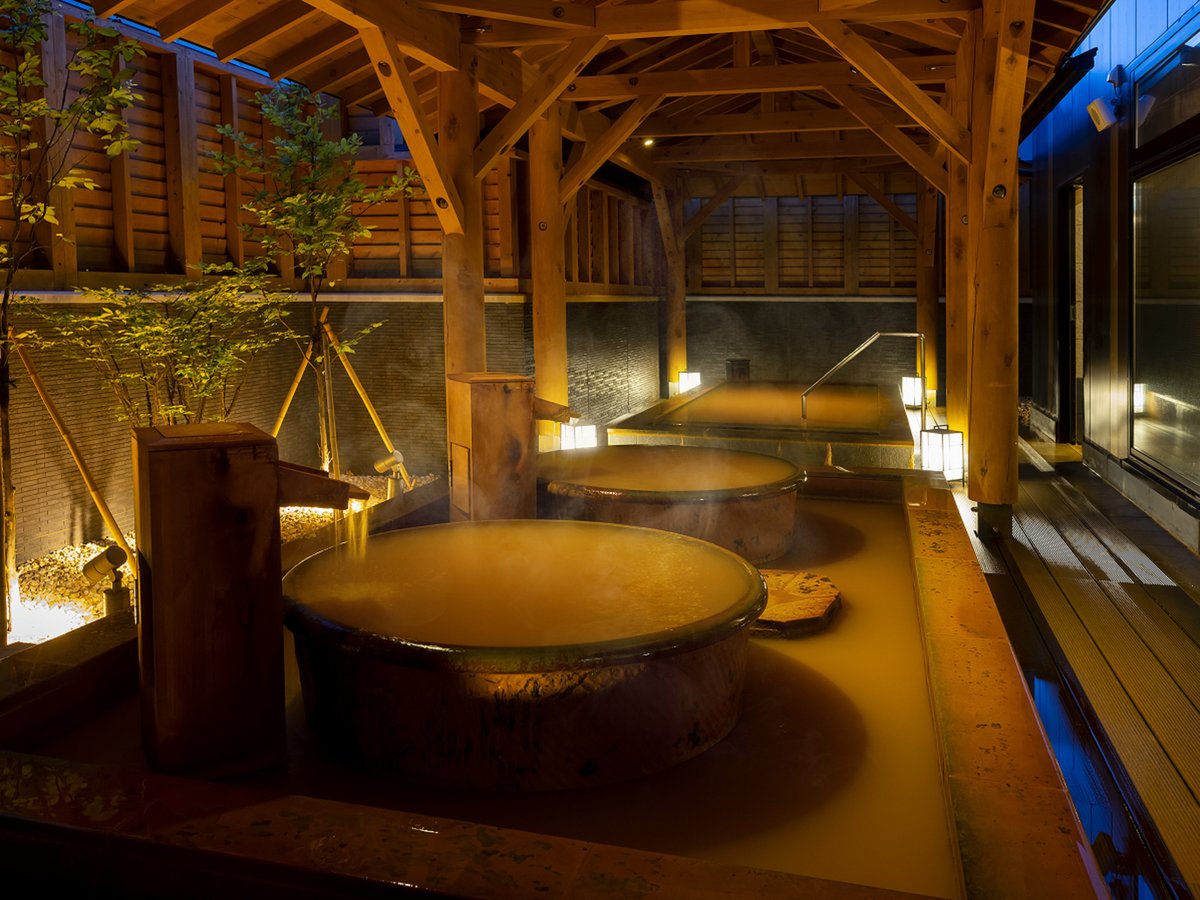 赤湯が特徴の源泉かけ流し温泉「海神の湯」情緒ある日本庭園風で落ち着いた雰囲気を醸し出す露天風呂。