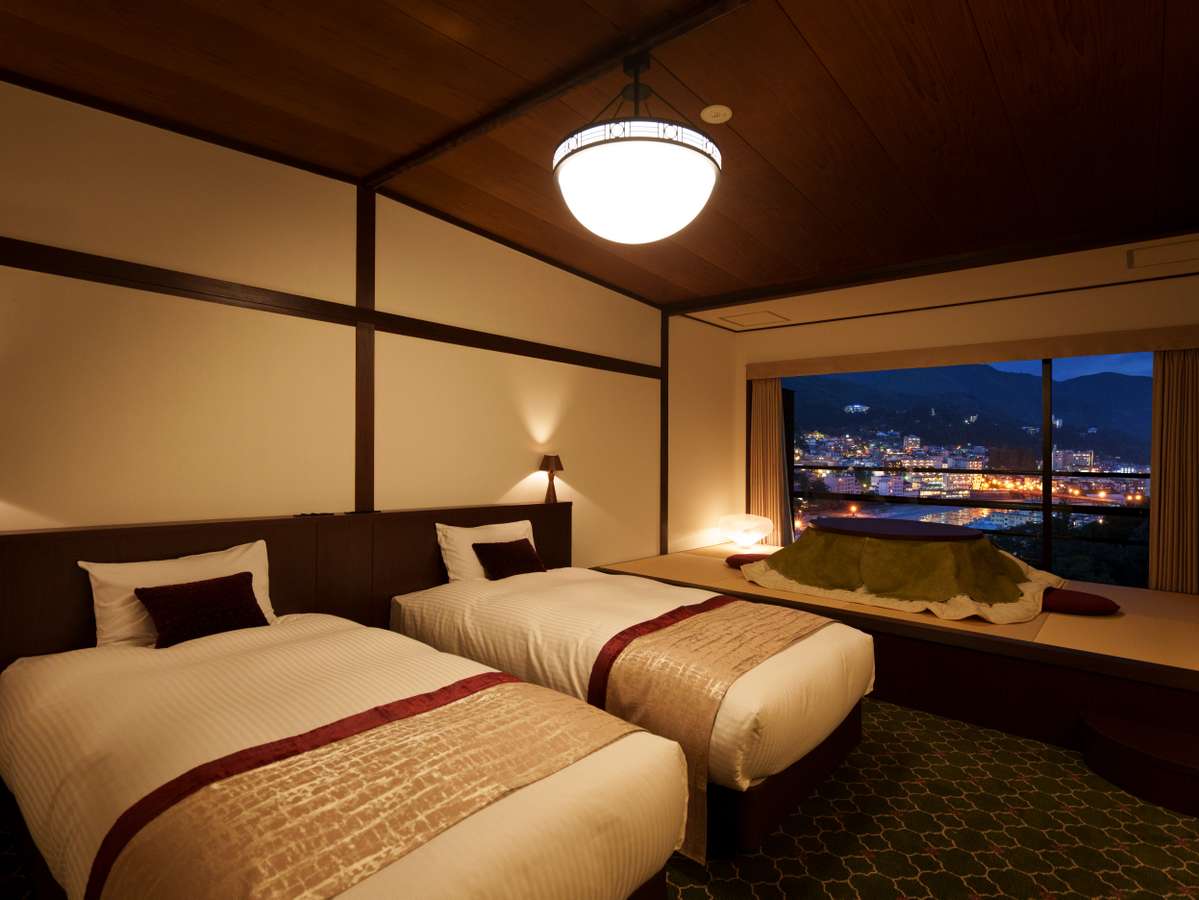【リニューアル新客室】窓から綺麗な夜景一望。ツインベッド&畳スペースに掘りごたつ付き