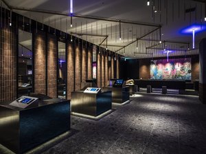【7F_フロントカウンター】ススキノのネオンも想起させるカラフルな空間アートを背景にしたフロント