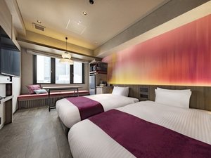 【デラックスツイン】窓際にベンチソファとテーブルを備えた、ゆっくり寛げるお部屋です。