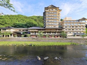 【萬国屋の全景】温海川沿いの緑豊かな立地