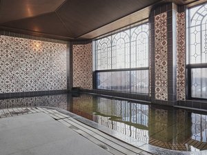 【女性大浴場】総タイル張り、窓にはアイアンフレームを施したアールデコスタイルの大浴場