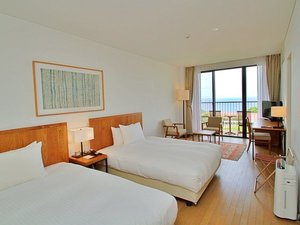 落ち着きある木目調のデラックスルーム。客室備え付けのお風呂からも外の景色をご覧いただけます。