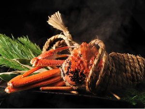 【冬の名物料理】活ずわい蟹のしめ縄蒸し。塩水に浸した縄を蟹に巻きつけて蒸し上げるダイナミックな一品